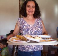 Voluntario sirviendo a niños en Comedor El Refugio